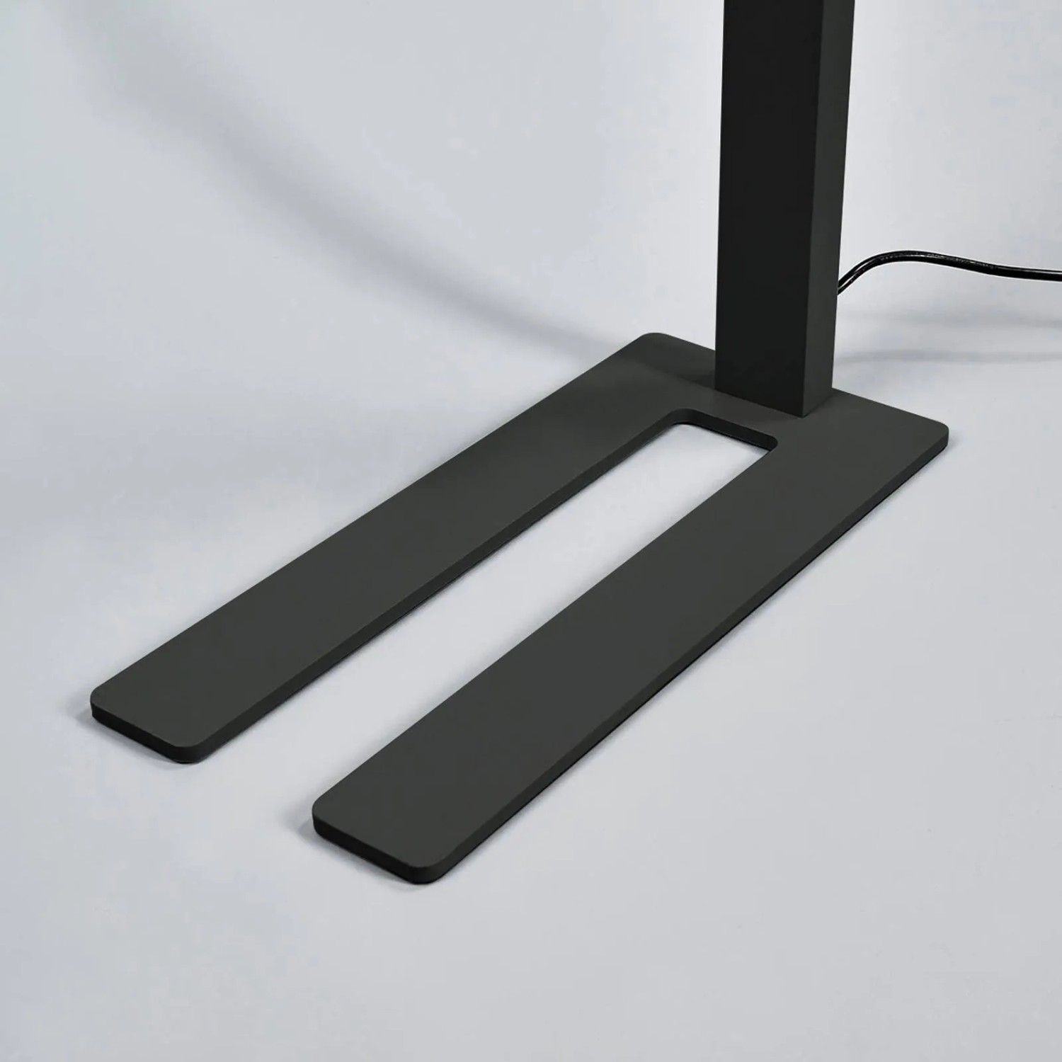 Detailaufnahme der schwarzen Arcchio LED Bürostehleuchte Jolinda mit U-förmigem Fuß.