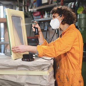 Frau benutzt Worx MakerX Akku-Airbrush WX742.9 zum Farbauftrag auf einen Bilderrahmen.