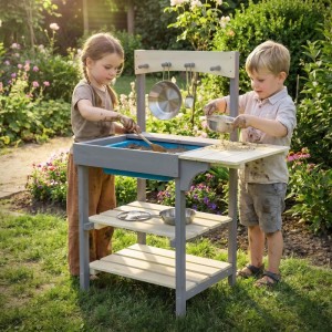 Kinder spielen mit der Joyz Matschküche aus Holz mit Zubehör im Garten.