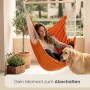 Orangefarbener AMANKA Hängesessel mit Frau und Hund auf Balkon. Bequemer Baumwoll-Schwebesessel für Entspannung.