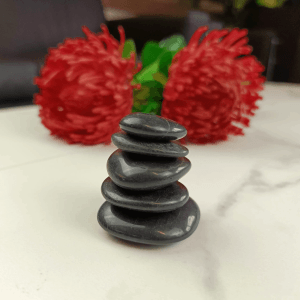 Gestapelte, polierte, schwarze Zierkieselsteine (2-3 cm) von Intergarden, ideal als Gartendeko.