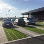 Steingraue HL Drainpflaster Füllsteine in Rasengitter auf einem Parkplatz mit Autos.