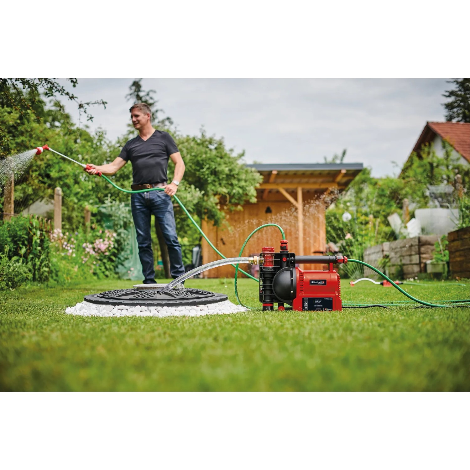 Einhell GE-AW 1042 FS Hauswasserautomat im Einsatz mit Wasserstrahl im Garten.