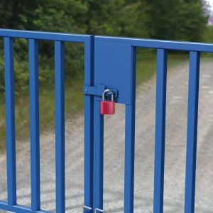 Rotes Basi Vorhangschloss Set an blauem Metalltor befestigt. Ideal zum Sichern von Toren.