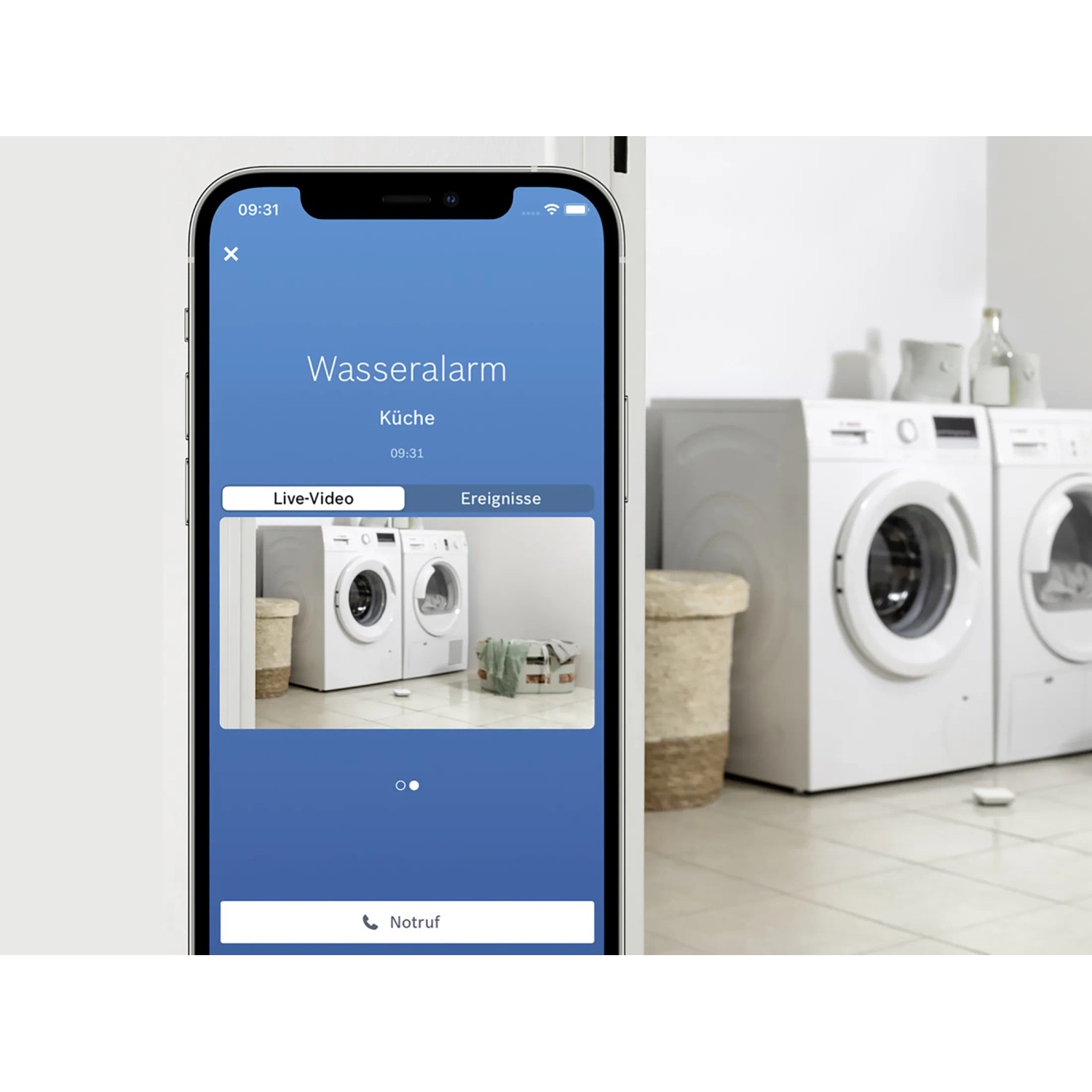 Smartphone mit Bosch Smart Home App und Wassermelder-Alarm in Waschküche.