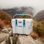 Graue Lifetime Kühlbox Campingbox (26,5 Liter) mit blauem Griff auf Felsen.