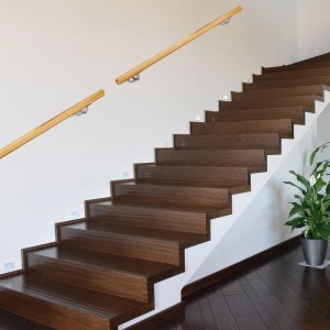 Heller Buchenholz Handlauf mit Edelstahlhaltern an weißer Wand über dunkler Holztreppe. Ideal für Treppen.