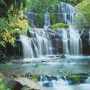 Komar Fototapete Pura Kaunui Falls: Mehrstufiger Wasserfall umgeben von üppigem Grün.