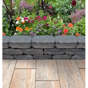 Diephaus Mauerstein Collo Basalt als Beeteinfassung mit Blumen im Hintergrund.