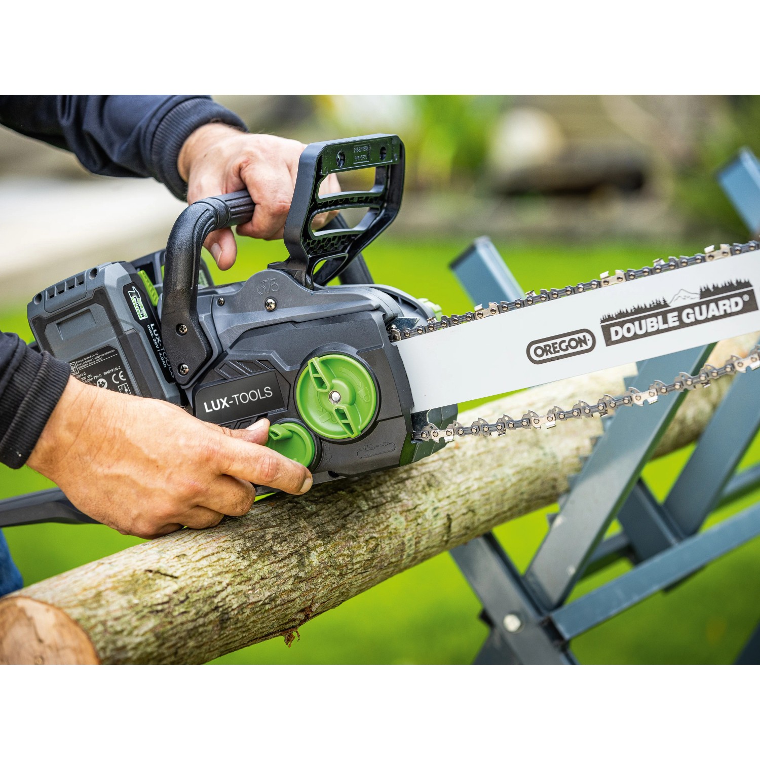 LUX-TOOLS Akku-Kettensäge A-KS-2x20/405 in Aktion beim Sägen eines Baumstamms.