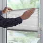 Graues Gardinia Plissee Solo (60x130cm) am Fenster, bedienbar per Hand. Sichtschutz ohne Bohren.