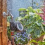 Gardena Bewässerungscomputer Flex am Wasserhahn mit laufender Bewässerung.