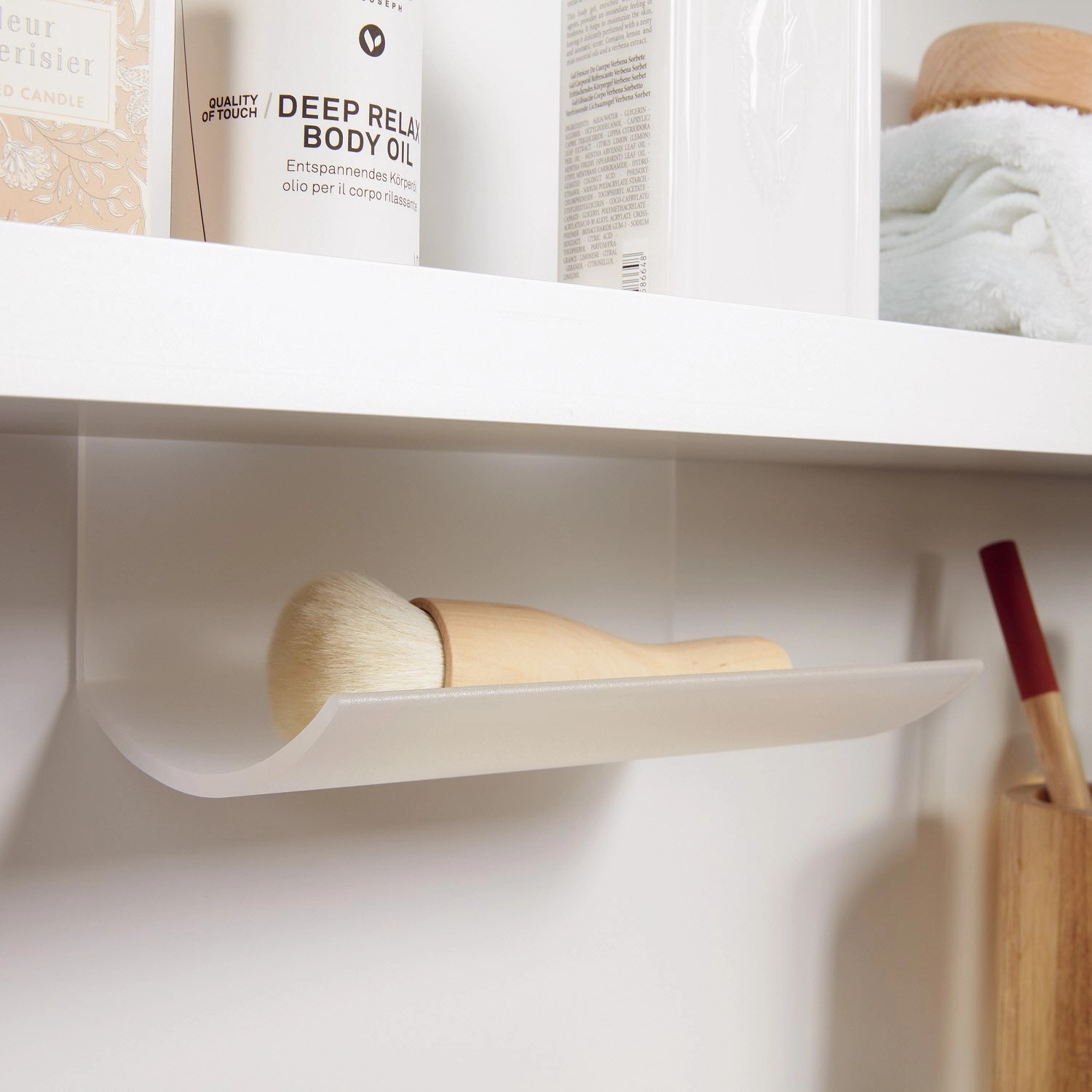 Detailaufnahme: Ablage im Spiegelschrank My View Now von Villeroy & Boch mit Pinsel und Kosmetikprodukten.