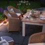 Paulmann Outdoor Minipoller Classic im Gartenambiente. Anthrazitfarbene Leuchte beleuchtet Weg neben Tisch und Stühlen.