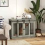 Grauer PawHut Hundekäfig aus MDF und Stahl mit Schiebetüren, genutzt als Hundehütte im Wohnzimmer.
