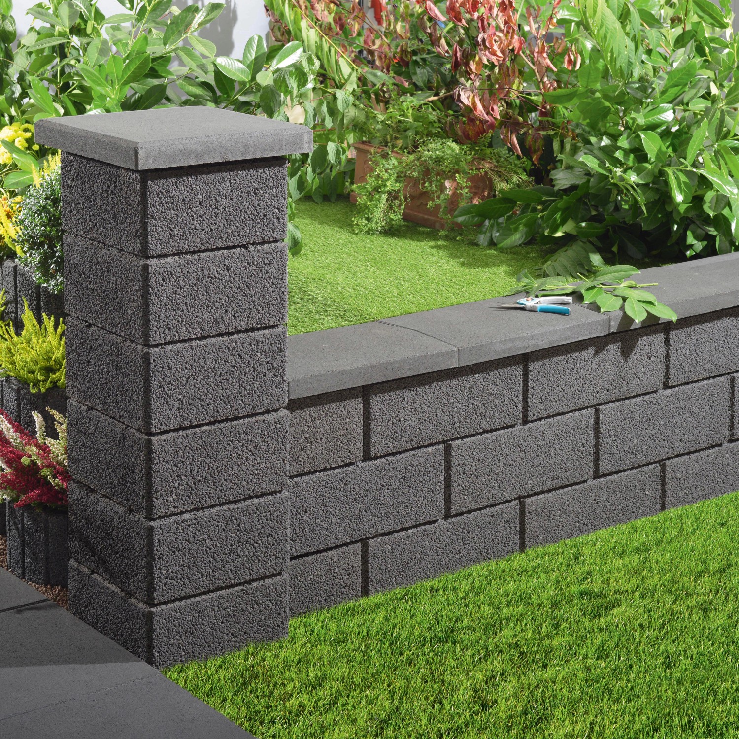 Anthrazit Gartenmauer aus Beton mit Pfeiler und Abdeckung als Grundstückseinfassung.