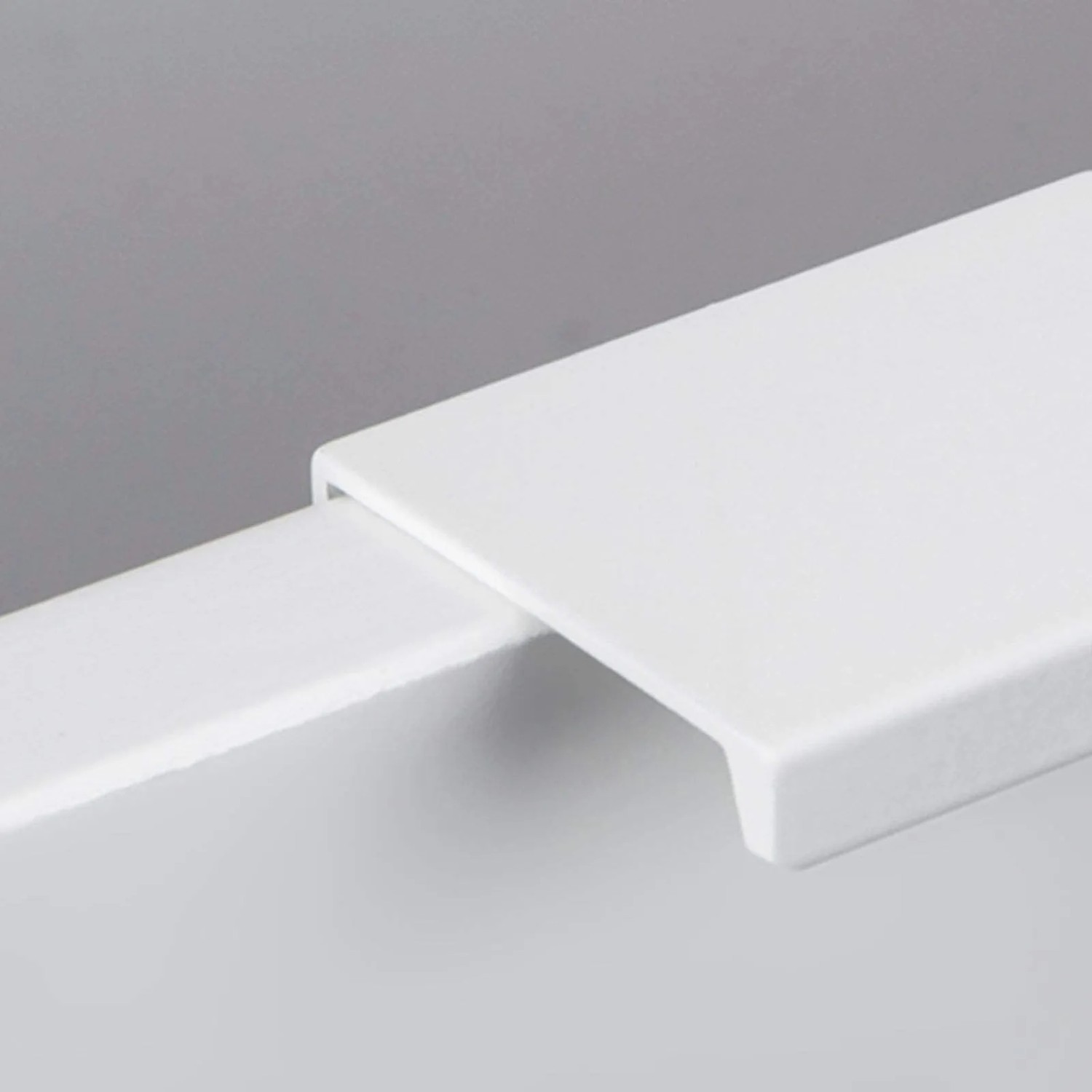 Weiße SOTECH BLANKETT Jane Griffleiste aus Aluminium, als Profilgriff an einer Möbelfront montiert.