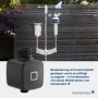 Homematic IP Bewässerungsaktor und Wettersensor im Garten. Der dunkle Aktor steuert die automatische Gartenbewässerung wetterabhängig.