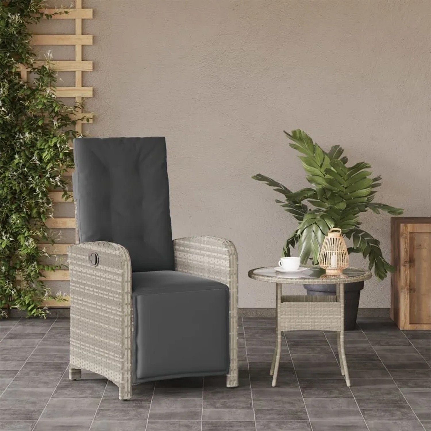 Hellgrauer Poly Rattan Gartensessel mit anthrazitfarbenen Polstern und verstellbarem Fußteil auf Terrasse.