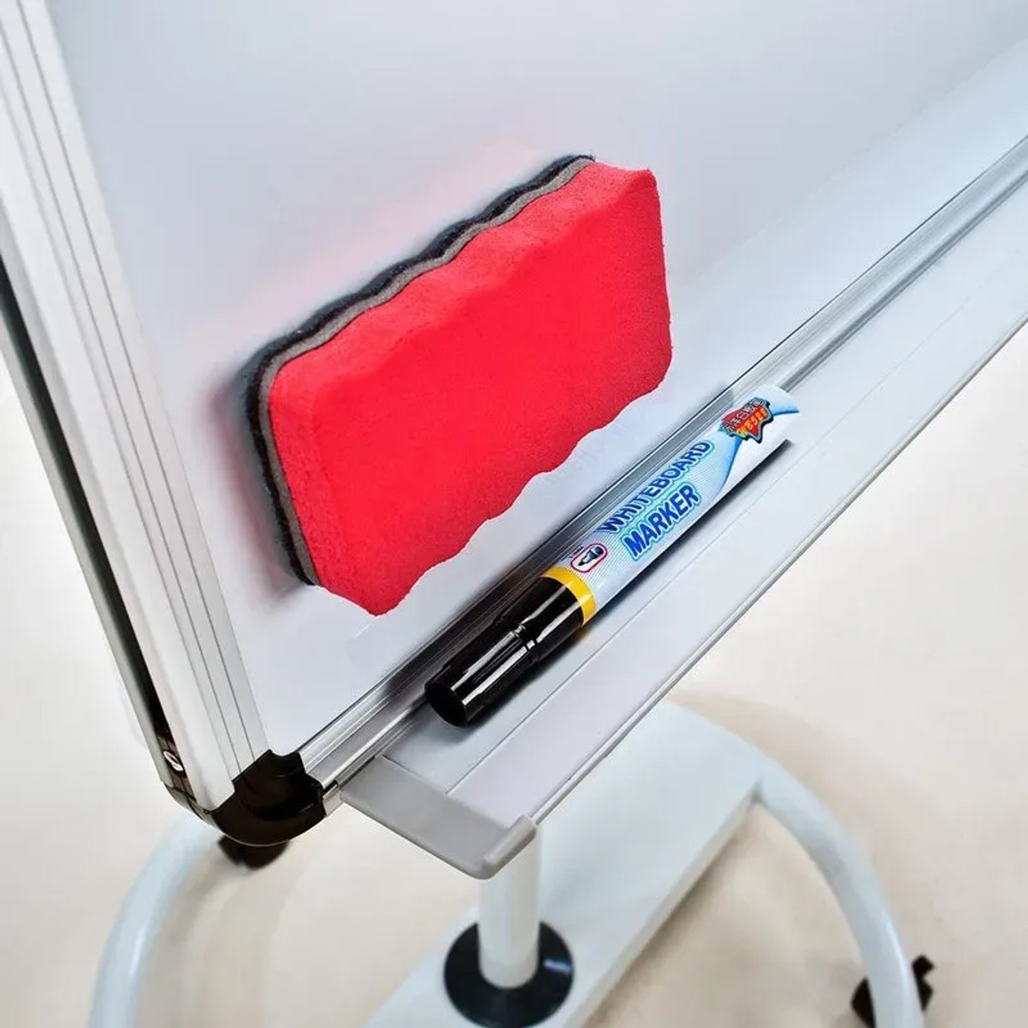 Detailaufnahme Flipchart Shark: Whiteboard-Marker und roter Schwamm am höhenverstellbaren Rollenfuß.