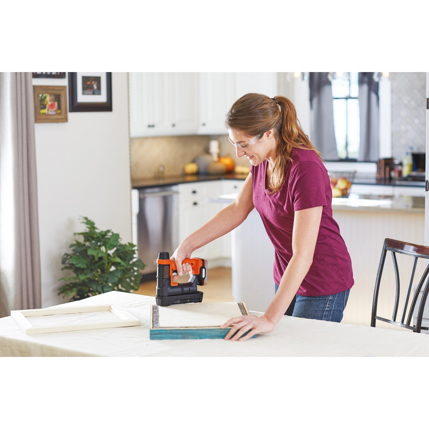 Frau benutzt Black+Decker Akku-Tacker/Nagler BDCT12N zum Heften von Holzrahmen.