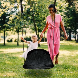 Mutter und Kind mit Roxy Nestschaukel als Zubehör für den Spielturm im Garten.