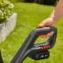 Detailaufnahme des Gardena Akku-Rasentrimmers ComfortCut 23/18 mit Hand am Griff und Akku.
