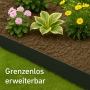 Anthrazit Metall Rasenkante trennt Rasen von Beet mit Pflanzen. Robuste Beeteinfassung für saubere Garten-Abgrenzung.