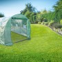 Freistehendes, grünes Tunnelgewächshaus mit aufrollbarer Tür im Garten.