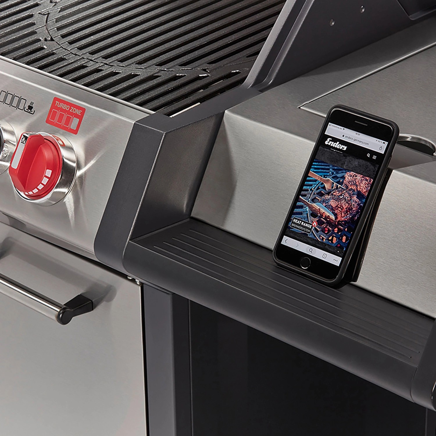 Enders Gasgrill Monroe Pro 4 SIK Turbo mit Seitenablage und Smartphone.