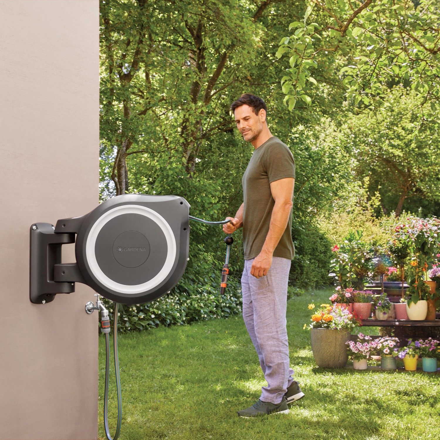 Gardena Wand-Schlauchbox RollUp XL mit 35 m Schlauch im Einsatz im Garten.