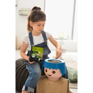 Mädchen bepflanzt Lechuza Grow Your Own Pflanz-Set (schwarz) mit Weizengras-Samen.