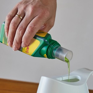 Seramis Vitalnahrung wird in ein Gefäß gegossen. Flüssigdünger für Grünpflanzen und Palmen.