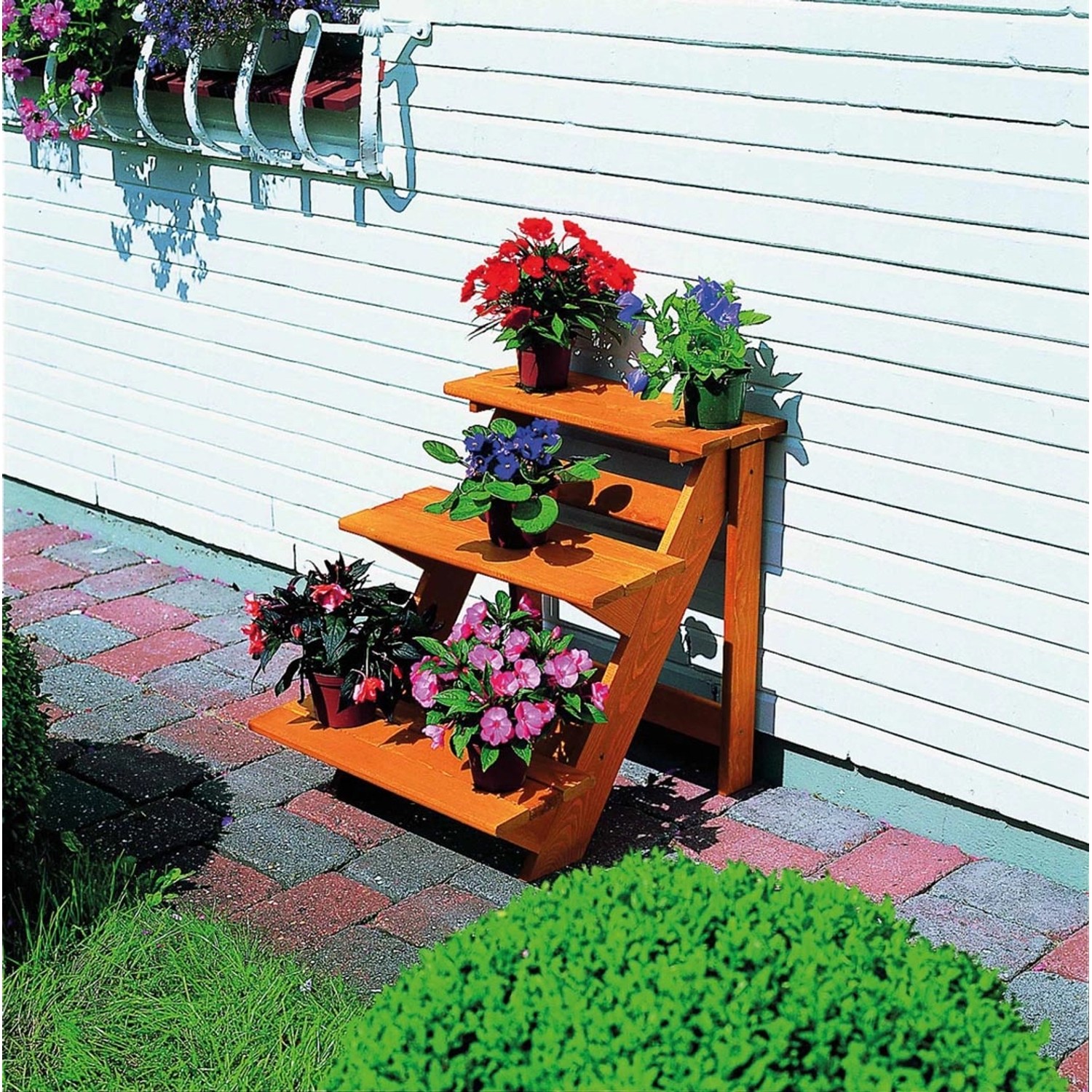 Kleine, honigbraune Promadino Blumentreppe aus imprägniertem Kiefernholz mit drei Stufen und bunten Blumen.