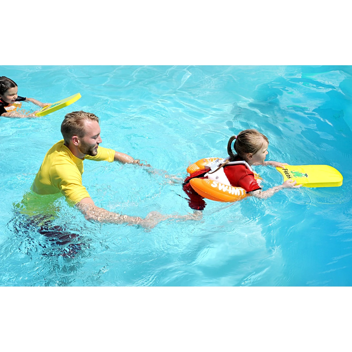 Kind mit gelbem Freds Swim Academy Schwimmreifen Classic im Pool, betreut von einem Erwachsenen.