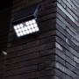 Schwarze Lutec LED Solar-Wandleuchte Tuda mit Bewegungsmelder an Backsteinwand.