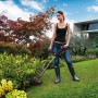 Frau trimmt Rasen mit Worx Akku-Rasentrimmer WG163E.9 im Garten.