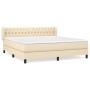 Cremefarbenes Boxspringbett 180x200 cm mit Stoffbezug und gestepptem Kopfteil.