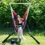 Frau liest entspannt in einem bunten AMANKA Hängesessel mit Holzstab im Garten. Ideal für Outdoor & Indoor.