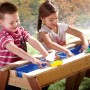Axi Sand- und Wasser-Picknicktisch Nick mit zwei Kindern beim Spielen mit Booten.