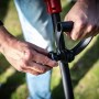 Skil Akku-Fugenreiniger: Hand justiert Griff an dem Gartenhandgerät für Unkrautentfernung.