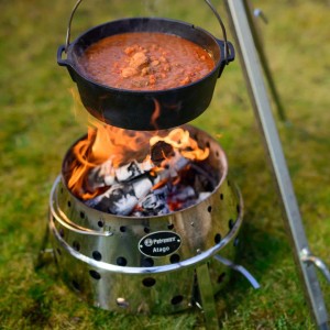 Petromax Atago Holzkohlegrill aus Edelstahl mit Dutch Oven über dem Feuer.