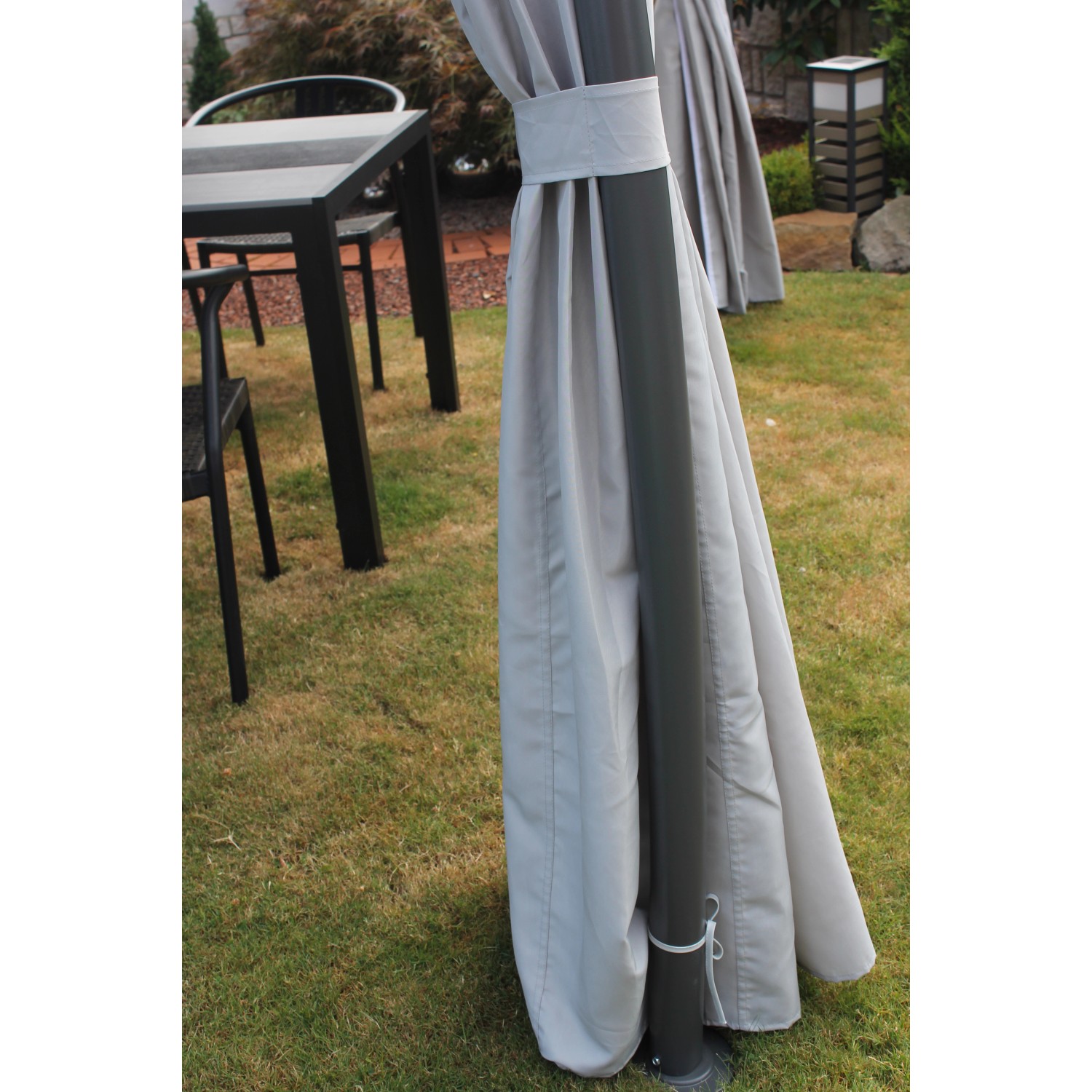 Detailaufnahme Pavillon Milena: Graue Seitenwand am Stahlrohr-Gestell im Garten.