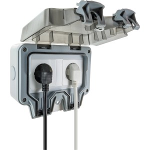 Schwaiger Aufputz-Außensteckdose, 2-fach, hellgrau, mit zwei eingesteckten Stromkabeln.