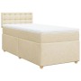Cremefarbenes Boxspringbett 90x190 cm mit Matratze und Stoffbezug.