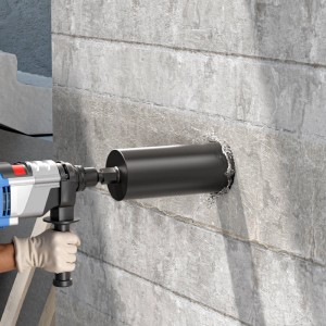 Schwarze Wiltec Diamantbohrkrone bohrt mit Wasser in graue Betonwand. Hand hält Bohrmaschine. Präzise Kernbohrung.