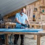 Mann schleift blaue Holzplatte mit Bosch Exzenterschleifer und Schleifblatt C470.