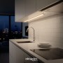 Flache Oktaplex LED Unterbauleuchte aus Aluminium in moderner Küche. Warmweißes Licht beleuchtet Arbeitsplatte und Spüle.