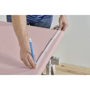 Zuschneiden einer Knauf Sonicboard Schallschutzplatte mit Zollstock und Stift.