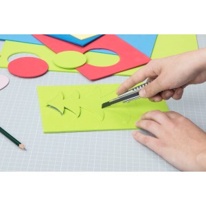 Wolfcraft Abbrechklingen-Messer schneidet grüne Schaumstoffplatte in Form eines Weihnachtsbaums.